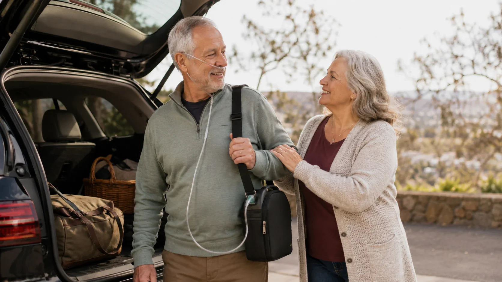 Older man wearing a nasal cannula and carrying a portable oxygen concentrator while standing beside a car with his wife.
