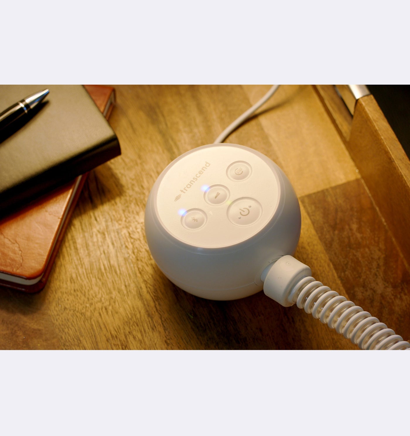 White electronic device with a coiled cable on a wooden surface