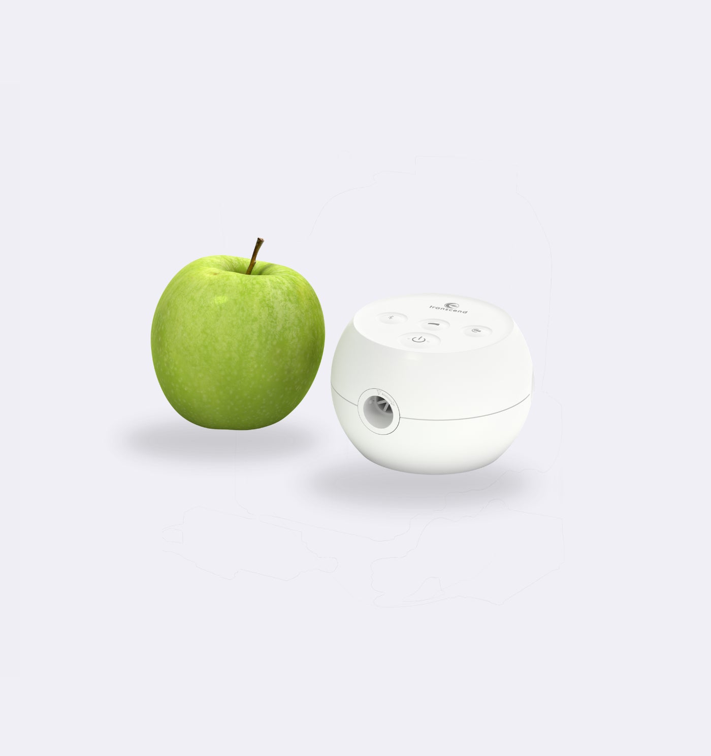 Green apple and white pencil sharpener on a light gray background