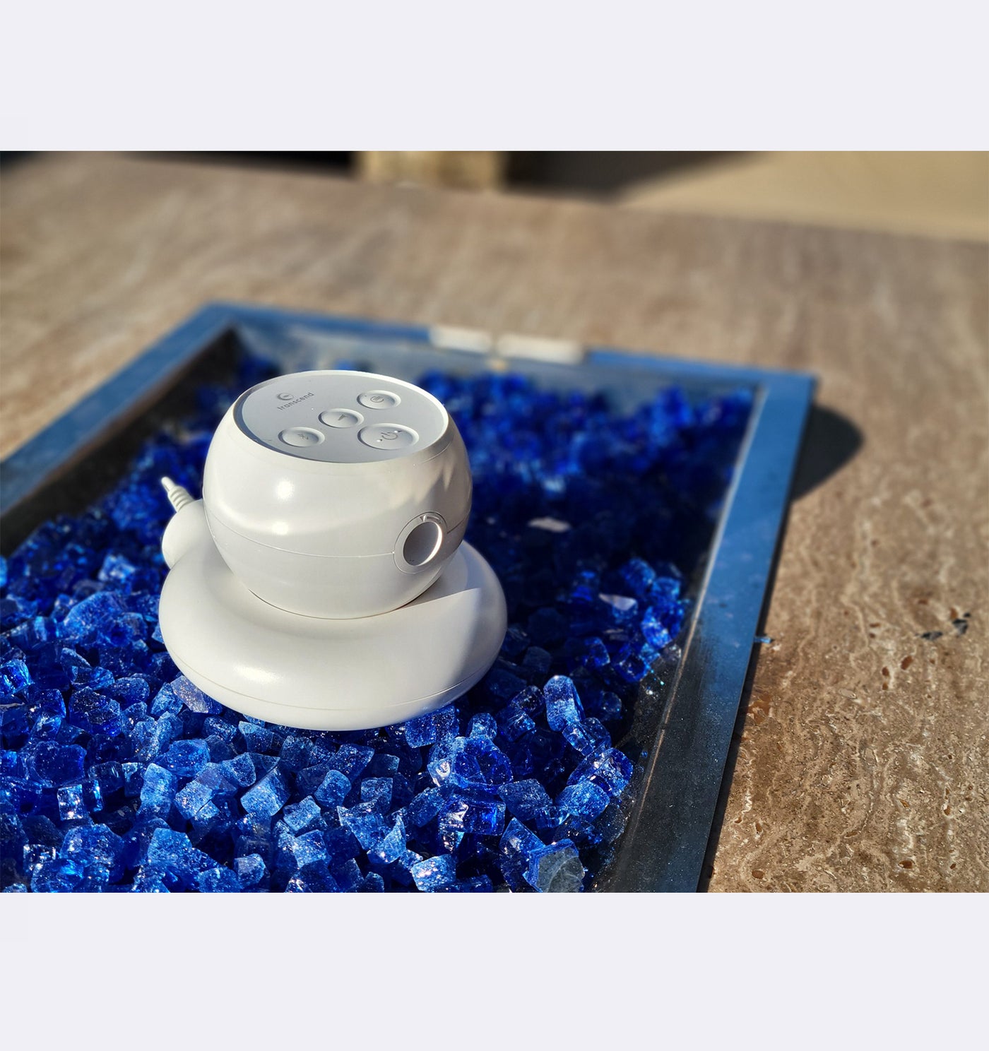 White electronic device on blue decorative stones with a blurred background