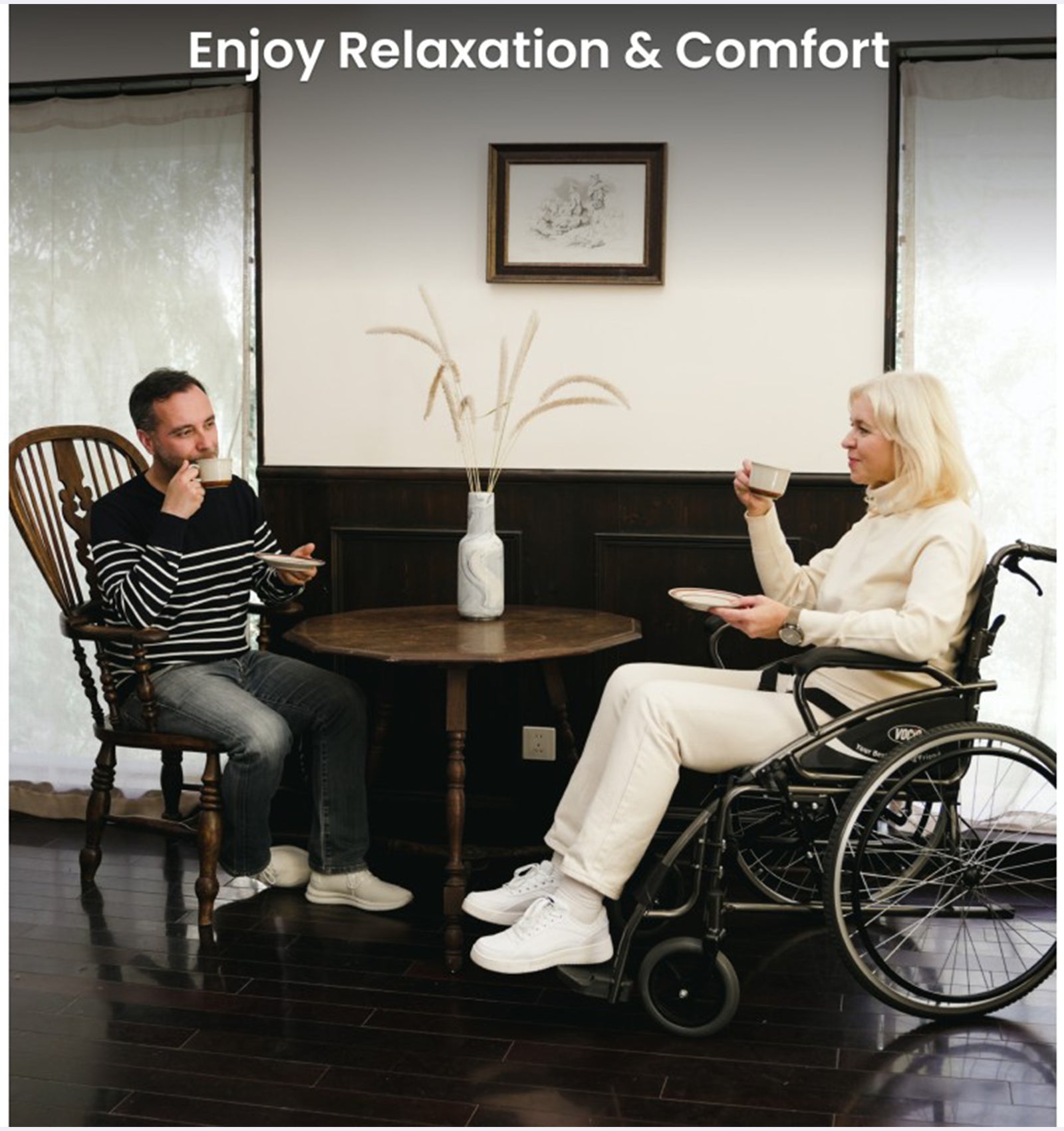 Two people sitting at a table, one in a wheelchair, enjoying relaxation and comfort.