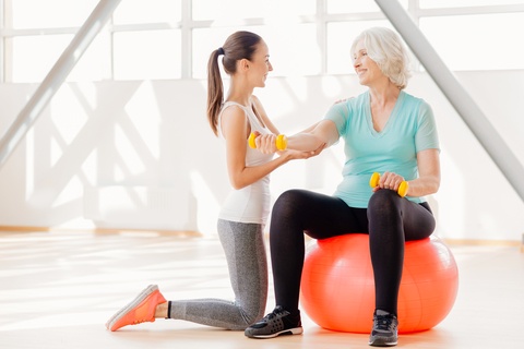 senior woman working out with a personal trainer