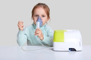 little girl using a nebulizer