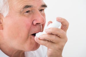 older man using an inhaler