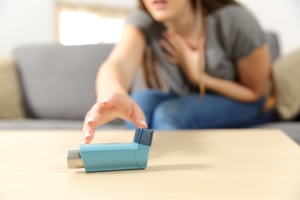 women reaching for asthma inhaler