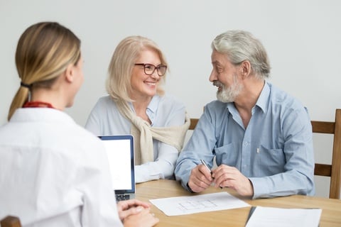 a senior couple talking with a doctor about options for treatment